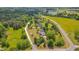 Expansive aerial view of a countryside home with lush greenery, a long driveway, and a serene lake nearby at 303 Crooked Meadow Ln, Hillsborough, NC 27278