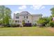 Expansive backyard featuring lush lawn and the back of the house with solar panels at 303 Crooked Meadow Ln, Hillsborough, NC 27278