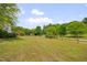 Large backyard with lush green lawn and surrounding trees at 303 Crooked Meadow Ln, Hillsborough, NC 27278