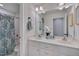 Bright bathroom features a double vanity and tub-shower with blue patterned curtain at 303 Crooked Meadow Ln, Hillsborough, NC 27278