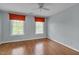 Empty bedroom with wood floors, two windows, and a ceiling fan at 303 Crooked Meadow Ln, Hillsborough, NC 27278