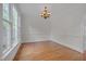 Dining room with hardwood floors, chandelier, and large windows offering natural light at 303 Crooked Meadow Ln, Hillsborough, NC 27278