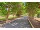 Long driveway lined with tall trees leads to an electronic gate enhancing privacy at 303 Crooked Meadow Ln, Hillsborough, NC 27278