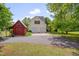 Exterior showcasing a two-car garage and a red outbuilding on the expansive driveway at 303 Crooked Meadow Ln, Hillsborough, NC 27278