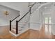 Bright foyer with hardwood floors, staircase, and views into adjacent rooms at 303 Crooked Meadow Ln, Hillsborough, NC 27278