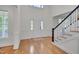 Bright foyer featuring hardwood floors, staircase, and white front door at 303 Crooked Meadow Ln, Hillsborough, NC 27278