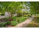 Beautifully landscaped front yard featuring a variety of trees, flowering plants, and a concrete walkway at 303 Crooked Meadow Ln, Hillsborough, NC 27278