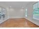 Bright living room with hardwood floors, white trim, and windows overlooking the yard at 303 Crooked Meadow Ln, Hillsborough, NC 27278