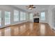 Bright living room with hardwood floors, fireplace, ceiling fan, and multiple windows at 303 Crooked Meadow Ln, Hillsborough, NC 27278