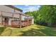 View of the backyard featuring a wooden deck with pergola, shed, and a lush green lawn at 3069 Buttonwood Ln, Clayton, NC 27520