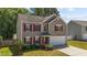Charming two-story home with a well-manicured lawn, red shutters, and attached two car garage at 3069 Buttonwood Ln, Clayton, NC 27520