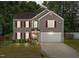 Charming two-story home boasts red shutters, a well-maintained lawn, and an attached two car garage at 3069 Buttonwood Ln, Clayton, NC 27520