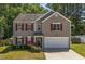 Charming two-story home boasts red shutters, a well-maintained lawn, and an attached two car garage at 3069 Buttonwood Ln, Clayton, NC 27520