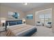 Bedroom with blue accents, two art pieces, sitting area, and natural light at 309 Windy Peak Loop, Cary, NC 27519