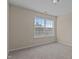 Bright bedroom with neutral walls and carpet, showcasing a large window for natural light at 309 Windy Peak Loop, Cary, NC 27519