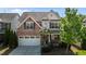 Charming home showcasing manicured lawn, brick accents, and a two-car garage at 309 Windy Peak Loop, Cary, NC 27519