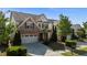 Beautiful home exterior featuring a two-car garage, stone accents, and lush landscaping at 309 Windy Peak Loop, Cary, NC 27519