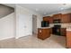 Open kitchen featuring wood cabinets, tile flooring, a black refrigerator, and access to the second floor at 309 Windy Peak Loop, Cary, NC 27519