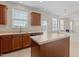 Well-lit kitchen featuring wood cabinets, a central island, and a view into an adjacent living space at 309 Windy Peak Loop, Cary, NC 27519