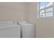 Functional laundry room equipped with a washer, dryer, and overhead shelving at 309 Windy Peak Loop, Cary, NC 27519