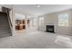 Spacious living room with fireplace, large windows, and open access to the adjacent kitchen at 309 Windy Peak Loop, Cary, NC 27519