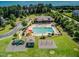 Aerial view of a community pool area with playground, clubhouse, and a spacious grassy field at 309 Windy Peak Loop, Cary, NC 27519