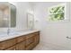 Bathroom featuring double vanity, wood cabinetry, and a window that offers natural light and pleasant outdoor views at 310 W Club Blvd, Durham, NC 27704