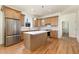 Bright kitchen features an island, stainless steel appliances, wood cabinets, and gorgeous hardwood floors at 310 W Club Blvd, Durham, NC 27704