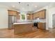 Bright kitchen features an island, stainless steel appliances, wood cabinets, and gorgeous hardwood floors at 310 W Club Blvd, Durham, NC 27704