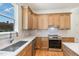 Modern kitchen with wooden cabinetry, stainless steel appliances, and white countertops at 310 W Club Blvd, Durham, NC 27704
