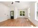 Open living room with white walls, hardwood floors, large windows, and stylish dark door at 310 W Club Blvd, Durham, NC 27704