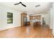 Bright living room open to the kitchen featuring hardwood floors, a ceiling fan, and a large window at 310 W Club Blvd, Durham, NC 27704