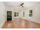 Open living room with white walls, hardwood floors, large windows and a stylish ceiling fan at 310 W Club Blvd, Durham, NC 27704