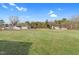 Expansive backyard on a sunny day with mature trees and other homes at 311 Nc 56, Louisburg, NC 27549