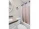 Bathroom featuring sink with stone counter, round mirror, and shower and tub combination with tile flooring at 311 Nc 56, Louisburg, NC 27549