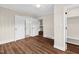 Spacious bedroom with crisp white trim, wood paneling and hardwood flooring. Access to a bathroom and kitchen at 311 Nc 56, Louisburg, NC 27549