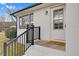Inviting front porch with a welcoming doormat, black railings, white painted brick, and natural light at 311 Nc 56, Louisburg, NC 27549