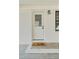 Inviting front entrance featuring a classic white door and a 'hello' doormat on a concrete porch at 311 Nc 56, Louisburg, NC 27549