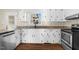 Bright kitchen with white cabinets, granite countertops, stainless steel dishwasher and appliances, and wood flooring at 311 Nc 56, Louisburg, NC 27549