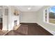 Bright living room featuring a decorative fireplace, fresh paint, hardwood floors, and a large window for ample natural light at 311 Nc 56, Louisburg, NC 27549