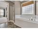 Bathroom with soaking tub, glass shower, and natural light at 3315 Swinford Ct, Raleigh, NC 27604
