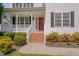 Inviting front porch with brick steps and walkway, complemented by blooming bushes at 3315 Swinford Ct, Raleigh, NC 27604