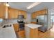 Kitchen boasts stainless appliances, an island, tile backsplash, and hardwood floors at 3315 Swinford Ct, Raleigh, NC 27604