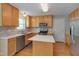Kitchen features an island, stainless appliances, tile backsplash, and wood floors at 3315 Swinford Ct, Raleigh, NC 27604
