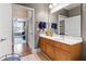 Bathroom vanity with wood cabinetry, a mirror, and a partial view into another room at 340 Allister Dr # 201, Raleigh, NC 27609