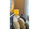 Close up of several pillows arranged on a bed with a yellow lamp nearby at 340 Allister Dr # 201, Raleigh, NC 27609