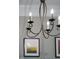 Close-up of the dining room chandelier with decorative artwork in the background at 340 Allister Dr # 201, Raleigh, NC 27609