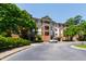 Exterior shot of the brick building, with an expansive parking lot and beautiful landscaping at 340 Allister Dr # 201, Raleigh, NC 27609