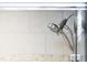 Close-up of a bathroom shower head with modern tile surround and glass door at 340 Allister Dr # 201, Raleigh, NC 27609