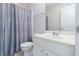 Clean bathroom with single sink vanity, large mirror, and toilet with a blue shower curtain at 3601 Sugar Tree Pl, Durham, NC 27713